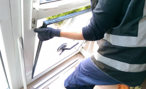 person replacing a glass unit for a double glazing window repair